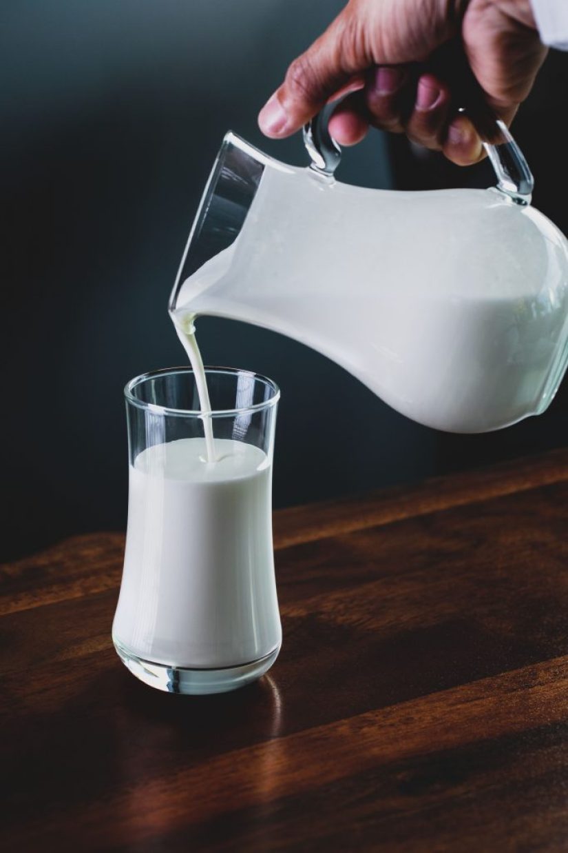 Pouring milk from a jug to a glass