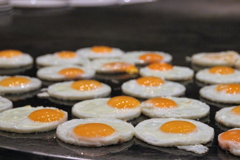 Eggs frying gloriously on a flat top